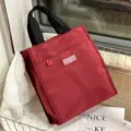 Red lunch bag tote with black handles and front zipper pocket for daily work school use. - Burgundy