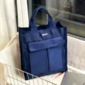 Λεπτομερής εικόνα της μπλε τσάντας με πολλαπλές θήκες σε όμορφο σκηνικό παρουσίασης. - Μπλε