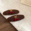 Vue détaillée de pinces à cheveux en peluche marron avec nœuds dorés et cerises en velours. - Pince BB - Cafè Cerise Nœud