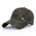 Detail view of the camouflage baseball cap showing its metal logo badge and fabric. - Dark Green