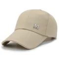 Beige canvas baseball cap with extended brim and metal M logo for outdoor sun protection. - Khaki