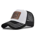 Close-up detail of mesh trucker cap showcasing contrast leather patch and zigzag brim embroidery. - Adjustable / CM817-13 Black & White Embroidery
