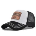 Detail shot of the black and white trucker hat featuring a stylish brown leather patch front. - Black With White Embroidery Line