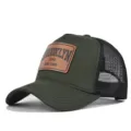 Close-up detail of the green mesh cap with brown leather patch and bold text design. - Army Green Black Mesh