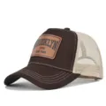 Close up detail of the brown mesh trucker hat featuring front leather patch branding elements. - Coffee & Beige Mesh