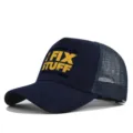 Gedetailleerd zicht op de donkerblauwe mesh trucker cap met gele bedrukte tekst. - Verstelbaar / Marineblauw