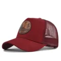 Vista detallada de la gorra trucker de malla burdeos con parche de cuero grabado. - Burdeos