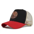 Vista detallada de la gorra trucker roja y negra de malla con un parche de cuero. - Rojo y Negro (Malla Beige)