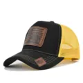 Klassieke truckerpet van mesh met lederen tractor-patch, stijlvolle zomerpet voor buiten. - Zwart met geel mesh