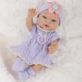 Detailed shot of 11-inch reborn baby doll featuring purple knit dress, cute headband and socks. - Purple Dress Style (Q11-048-056)