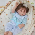 Detailed close-up of a lifelike reborn baby doll resting comfortably in a cozy bassinet. - Blue Polka Dot Set Style (Q20-002-062) / 50cm Reborn Doll