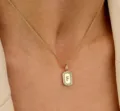 Detailopname van de gouden ketting met een rechthoekige hanger met zirkonia en letter F. - Letter F