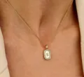 Gedetailleerde close-up van een delicate rechthoekige initialen ketting met schitterende zirkonia. - S