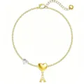 Dettaglio bracciale dorato con lettera A e ciondolo a cuore, gioiello elegante da donna. - Lettera A