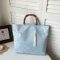 Elegante hellblaue Jacquard Handtasche mit Bambusgriff und weisser Quaste fuer Damen. - Mit Anhänger / Blau