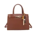 Bolso de mano marrón de cuero PU con cierre de giro elegante y dije de cuentas. - Marrón Con Colgante
