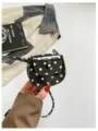 Detalle en primer plano del mini bolso de silla de charol con lunares blancos y negros. - Negro