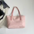 Detailed shot of the pink canvas tote bag featuring a cute silver star pattern and pink handles. - Pink