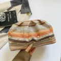 Vista detallada de un bolso de mano de paja tejido colorido con elegantes detalles de remaches dorados. - Marrón