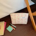 Dettaglio borsa cosmetica in corduroy con motivo fiocchi rosa, grande custodia portatile. - Fiocco Bianco