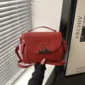 Sac à bandoulière rouge tendance pour femme, sac élégant avec serrure en métal et rivets. - Rouge