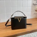Elégant sac seau noir en cuir avec fermoir métallique V doré et bandoulière réglable femme. - Noir
