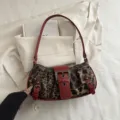 Modieuze damesschouderertas met luipaardprint, stijlvolle rode afwerking en coole gespen. - Rood