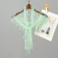 Detailed view of mint green lace triangle scarf hanging on a wooden hanger - 135cm (With Beaded Tassels) / Green