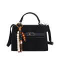 Sac à main noir avec poignée, fermeture métallique et pendentif en perles de bois. - Avec Pendentif / Noir