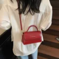 Elegante rote Umhängetasche aus Lackleder für Damen, schicke kleine Handtasche mit Griff. - Rot