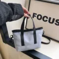 Grey small canvas tote bag with black handles and shoulder strap for casual daily use. - Blue