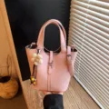 Rosa Leder Eimer Tasche für Damen, stilvolle Pendler Handtasche mit Schultergurt und Blumenanhänger. - Tasche mit Anhänger / Rosa