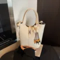 Beige Eimer Tasche für Damen, Retro Henkeltasche mit Blumen Anhänger und Umhängeriemen. - Gebrochenes Weiß
