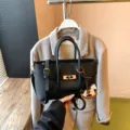 Schwarze Damentasche aus Leder mit Henkeln, elegantem Schultergurt und Pferdeanhänger. - Nur Einzelbeutel / Schwarz