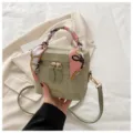 Primer plano detallado del bolso verde elegante con pañuelo de seda estampado en asa. - Con Ornamento / Verde