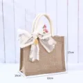 Natürliche Jute-Geschenktüte mit Spitzenschleife und 22x17x10cm Abmessungen - Xi-Symbol Anhänger Mit Spitze Schleife (Inklusive Seidenschal) / Klein (22x17x10cm) / Naturfarben