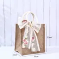 Umweltfreundliche Jutetasche mit floraler Spitzenschleife dekoriert, 21x23x15 cm - Xi-Symbol Anhänger Mit Spitze Schleife / A6 Vertikal (21x23x15cm) / Naturfarben