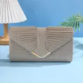 Detail van glanzende gouden avondtas met geplooide stof en een stijlvolle metalen sluiting. - Goud