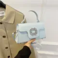 Elegante bolso de mano azul claro con brillante hebilla de pedrería para un estilo único. - Azul