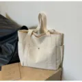 Canvas tote bag detail showing large capacity, durable fabric, and practical side pockets. - Beige with Lining