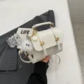 Bolso bandolera pequeño blanco para mujer, elegante bolso de mano de piel PU con peluche. - Con Ornamento / Blanco Roto