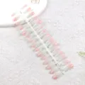 Vista de detalle de uñas postizas degradadas, exposición de tiras en rosa y verde menta. - Rosa Verde Olas Suaves