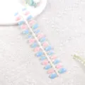 Primer plano de detalles de uñas postizas azules y rosas en una tira de plástico. - Azul Hielo Rosa Dulce