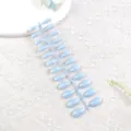 Primer plano de unas postizas azul claro con efecto ojo de gato en tira de muestra. - Azul Bruma Suave Transparente
