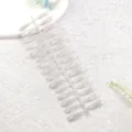 Vista detallada de uñas postizas efecto ojo de gato en soporte de plástico manicura. - Flor Estrella Blanca Transparente
