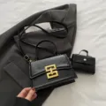 Pequeño bolso de hombro negro para mujer con un cierre dorado elegante y un estilo minimalista. - Con bolsa pequeña / Negro