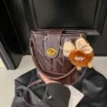 Μοντέδνα καπιτονέ τσάντα bucket για γυναίκες, καφέ δερμάτινη τσάντα ώμου με χαριτωμένο αξεσουάρ. - Με Κρεμαστό / Καφέ