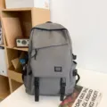 Lockerer großer grauer Rucksack für Schule, Reisen und Alltag im modernen schlichten Stil. - Grauer Frosch-Anhänger / Grau
