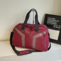 Grande borsa da viaggio sportiva rosso scuro con strisce riflettenti geometriche e manici. - Rosso