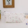 Gedetailleerde opname van een schattig bloemenetui met kanten rand op een wit bureau. - Roze
